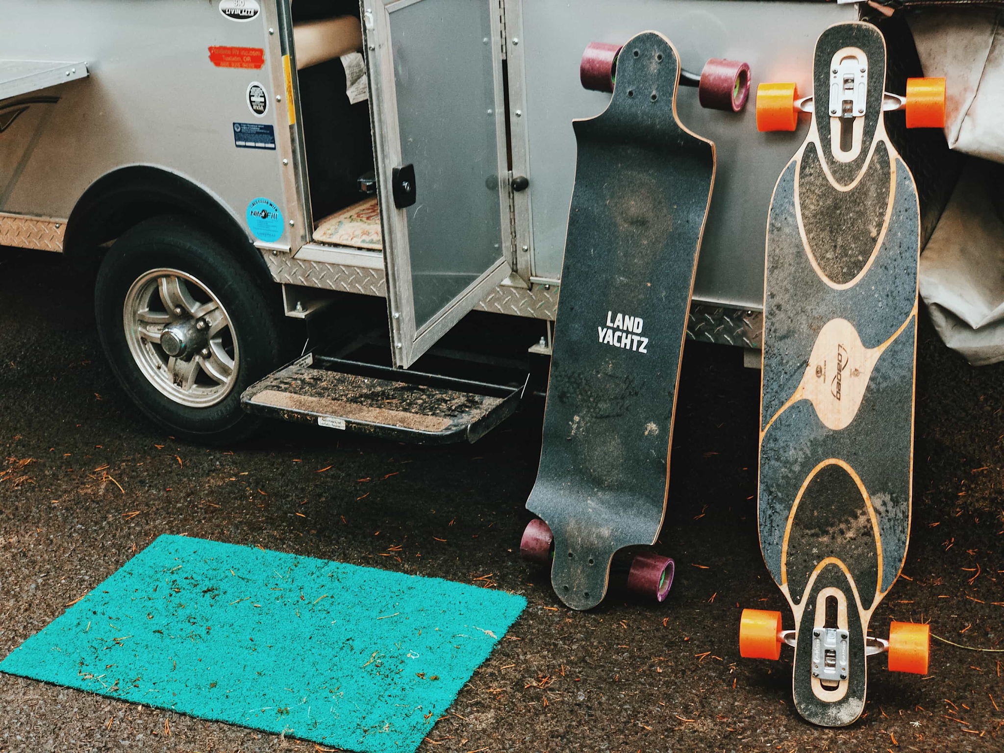 Two longboards lined up against a trailer.